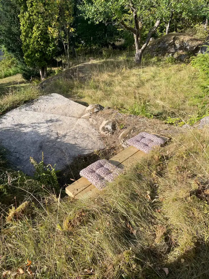 Sitzbank mit Kissen auf dem Felsen im oberen Garten