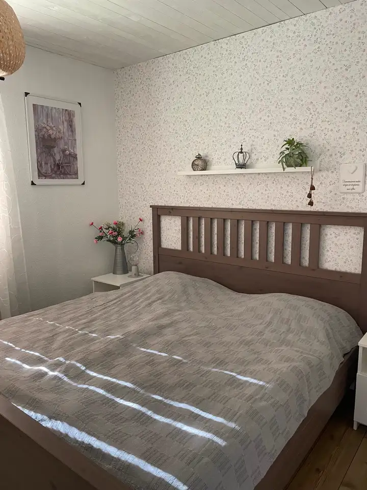 Schlafzimmer mit Doppelbett und Blümchentapete