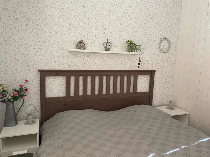 Doppelbett im ersten Schlafzimmer mit Nachttischen