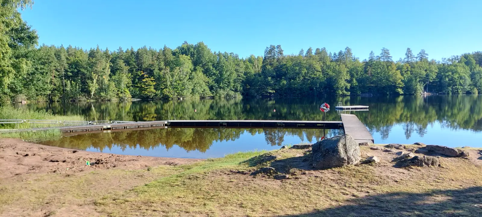 Badesteg am See Långsjön in Ankarsrum mit Wald am anderen Ufer