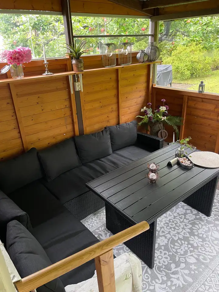 Wintergarten mit Lounge-Ecke und Blick in den Garten