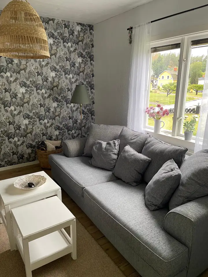 Wohnzimmer mit großem Sofa und Fenster zum Ort